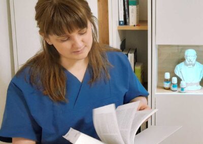 Darstellung der Therapeutin recherchierend im Arzneibuch